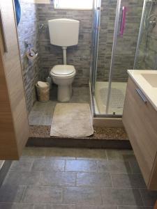een badkamer met een toilet en een douche bij Casa di Rosa in San Leone
