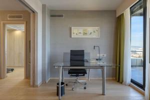 an office with a desk and a chair and a window at Radisson Blu Park Hotel Athens in Athens
