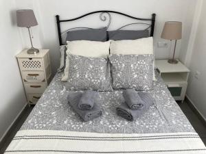 1 cama con 2 almohadas y toallas en Fantástico apartamento en Triana en Sevilla