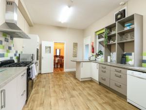 a kitchen with white cabinets and a hardwood floor at Clover Court in Great Yarmouth