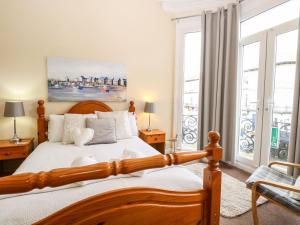 a bedroom with a wooden bed with white pillows at Clover Court in Great Yarmouth