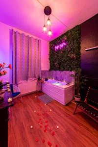 a living room with a tub and purple lighting at Suite Amazonia ~ Balnéo ~ Arrivée Autonome in Rouen