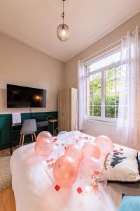 a bunch of balloons on a bed in a room at Suite Amazonia ~ Balnéo ~ Arrivée Autonome in Rouen