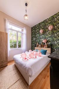um quarto com uma cama com porcos cor-de-rosa em Suite Amazonia ~ Balnéo ~ Arrivée Autonome em Rouen