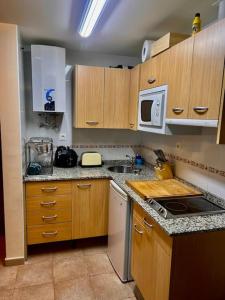 a kitchen with wooden cabinets and a stove top oven at APARTAMENTO Estación de ESQUÍ EN SAN ISIDRO in San Isidro