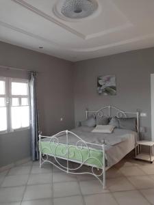 a bedroom with a bed in a room with a ceiling at Babhilds Residence in Bakau