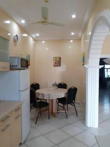 a kitchen with a table and chairs and a refrigerator at Babhilds Residence in Bakau