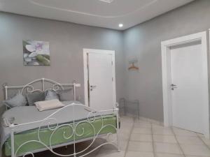 - une chambre avec un lit et un mur blanc dans l'établissement Babhilds Residence, à Bakau
