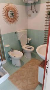 a bathroom with a toilet and a sink at Apartment in Porto Santa Margherita 43993 in Porto Santa Margherita di Caorle