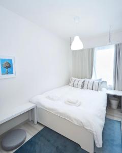 Un pequeño dormitorio con una cama blanca y una ventana en ONE STAGE HOTEL, en Tokio