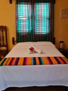 Hotel Maya Luna Adults Only في ماهاهوال: سرير مع بطانية ملونة ومنشفة عليها
