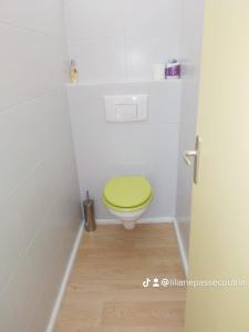 a bathroom with a toilet with a green lid at Les Remparts de vieux fort 2 in Saint-Louis