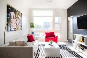 a living room with a couch and a red chair at Art-Inspired Loft with Mountain View - Zuni Lofts in Denver