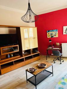salon z czerwoną ścianą i stołem w obiekcie Helios Home City Center w mieście Salerno