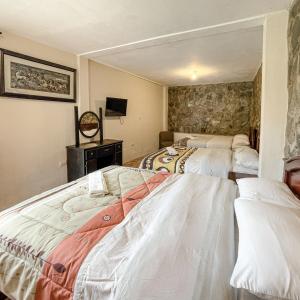 a bedroom with two beds and a tv in it at Quinta San Martín in Cuenca