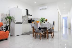- une cuisine et une salle à manger avec une table et des chaises dans l'établissement Apulia Modern apartment - Bari Airport, à Bitonto