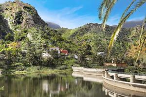a bridge over a river with mountains in the background at Casa Rural La Presa in Vallehermoso