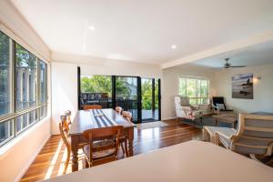 a living room with a table and chairs at Four Beaches-LJHooker Yamba in Yamba