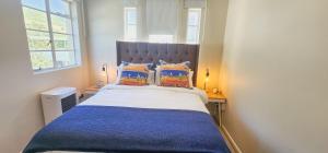 a bedroom with a large bed with blue sheets and pillows at The Tipsy Expat in Paarl