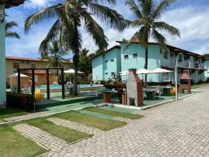 a resort with a swimming pool and palm trees at Pé na Areia in Porto Seguro