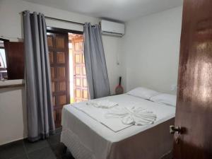 a bedroom with a white bed with a window at Pé na Areia in Porto Seguro +23 photos