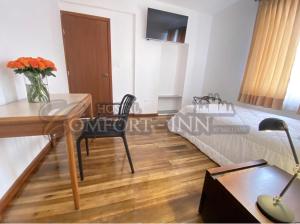 a bedroom with a desk and a bed and a table at HOSTAL COMFORT INN Torre A in Quito +28 photos