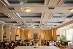a banquet hall with tables and chairs and chandeliers at Hotel Philippos Livadeia in Livadeia