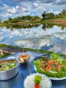 einen Tisch mit Tellern und Seeblick in der Unterkunft Hotel Fazenda Pousada da Serra in Goianésia