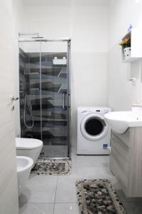 a bathroom with a shower and a toilet and a washing machine at Apulia Modern apartment - Bari Airport in Bitonto