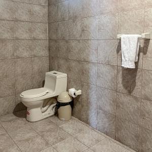 a bathroom with a toilet and a tiled wall at Quinta San Martín in Cuenca