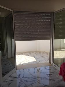 a room with a bed in a room with a window at Nouveau Appartement Avec Un Parking Gratuit in La Marsa