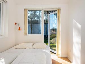 a bedroom with a bed in front of a window at Two-Bedroom Holiday home in Harboøre 4 in Harboør