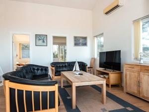 a living room with black leather furniture and a tv at 6 person holiday home in Harboøre-By Traum in Harboør