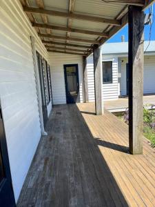 a porch of a house with a wooden walkway at Pt Hesse Luxury Coastal Homestead in Port Campbell