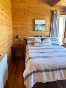 a bedroom with a bed in a wooden cabin at Pt Hesse Luxury Coastal Homestead in Port Campbell