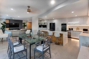 a kitchen and living room with a glass table and chairs at Allure on Hamilton Island by HIHA in Hamilton Island