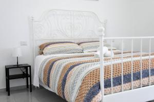 - un lit blanc avec une tête de lit et des oreillers blancs dans l'établissement Apulia Modern apartment - Bari Airport, à Bitonto
