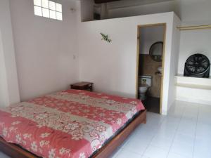 um quarto com uma cama vermelha num quarto em Casa Bony em Montañita