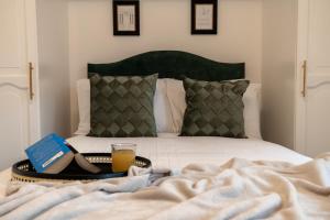 a bed with a tray with a book and a glass of orange juice at The Hydro Escape - 5* Event Venue *Free Parking* in Glasgow