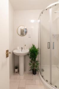 a white bathroom with a sink and a shower at The Hydro Escape - 5* Event Venue *Free Parking* in Glasgow +15 photos