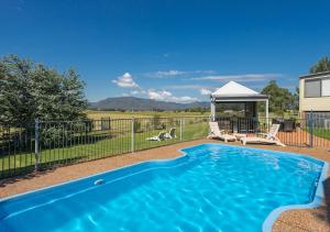 a swimming pool with two chairs and a gazebo at Maranda Country Estate 5 Bedrooms with Spa & Pool in Broke