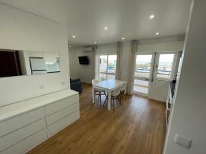 a kitchen and dining room with a table and chairs at Monte Gordo South Pearl Apartment in Monte Gordo