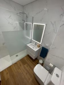 Baño blanco con aseo y lavamanos en Monte Gordo South Pearl Apartment, en Monte Gordo
