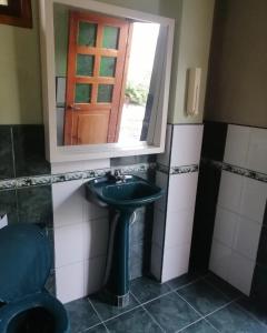 a bathroom with a sink and a mirror and a toilet at Casa Bony in Montañita