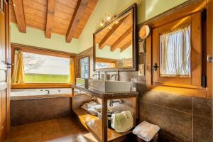 La salle de bains est pourvue d'un lavabo, d'une baignoire et d'une fenêtre. dans l'établissement A Toca Casas Rurales en Turegano Segovia, à Turégano