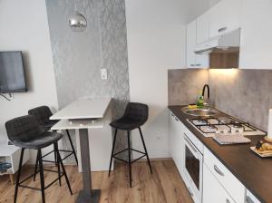 a kitchen with a sink and a counter with stools at Apartments with a parking space Karlovac - 20779 in Karlovac