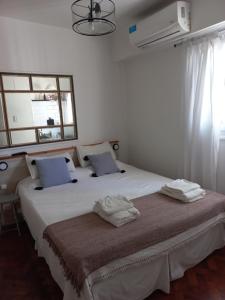 a bedroom with a large white bed with two pillows at Acogedor apartamento céntrico. Obelisco. in Buenos Aires
