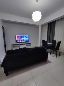 皮拉雅的住宿－KP - Negócios Globais，客厅配有黑色沙发和电视