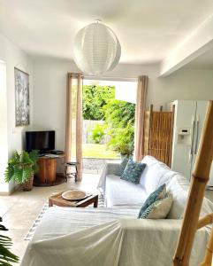 ein Wohnzimmer mit einem weißen Sofa und einem TV in der Unterkunft Ti Kay Ilets in Les Trois-Îlets