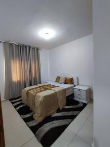 ein Schlafzimmer mit einem Bett in einem weißen Zimmer in der Unterkunft KP - Negócios Globais in Praia